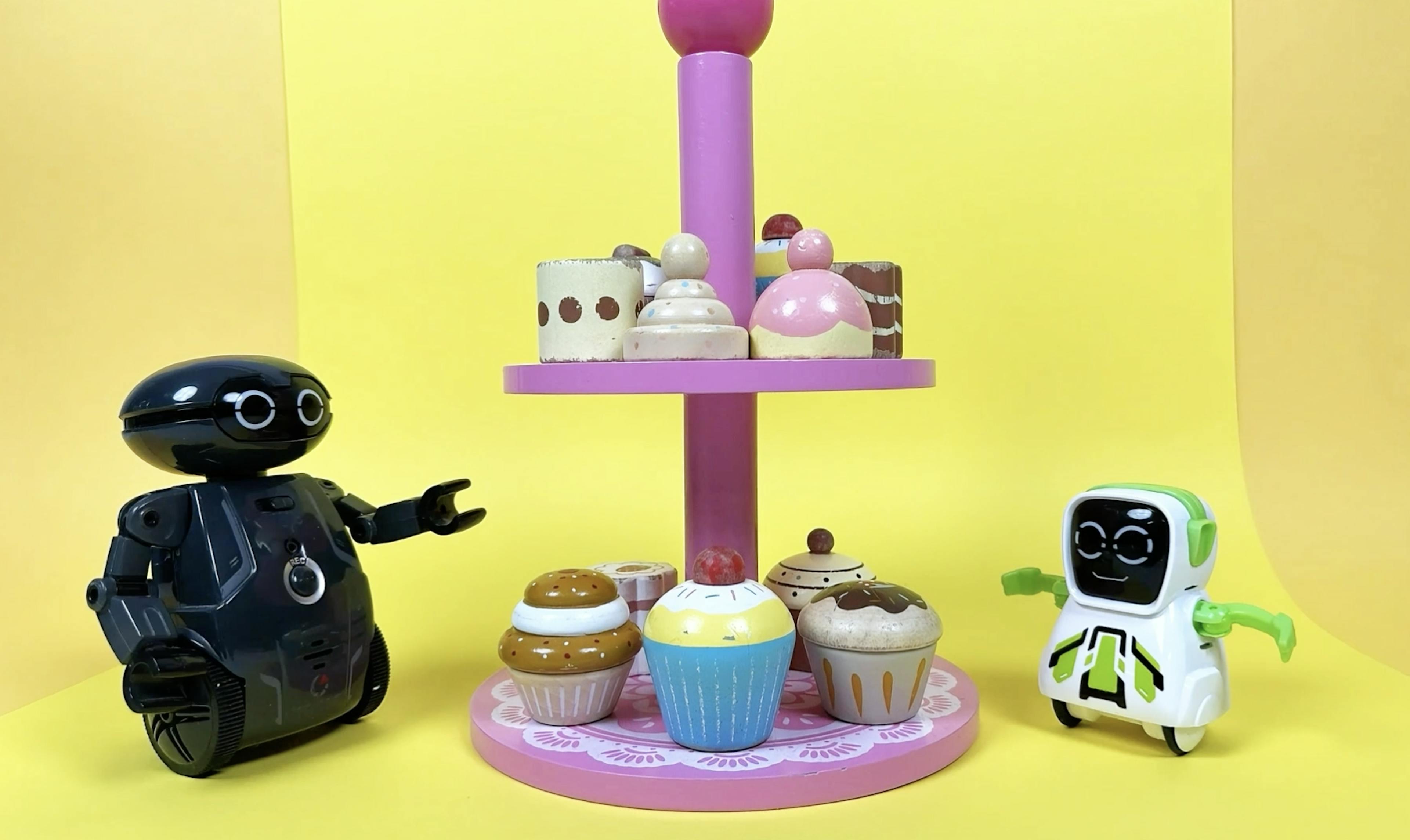 Two toy robots having sweets