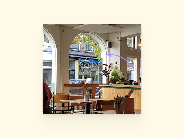 A photograph of the inside of the restaurant. A drawn on arrow points at the shape of the window. 