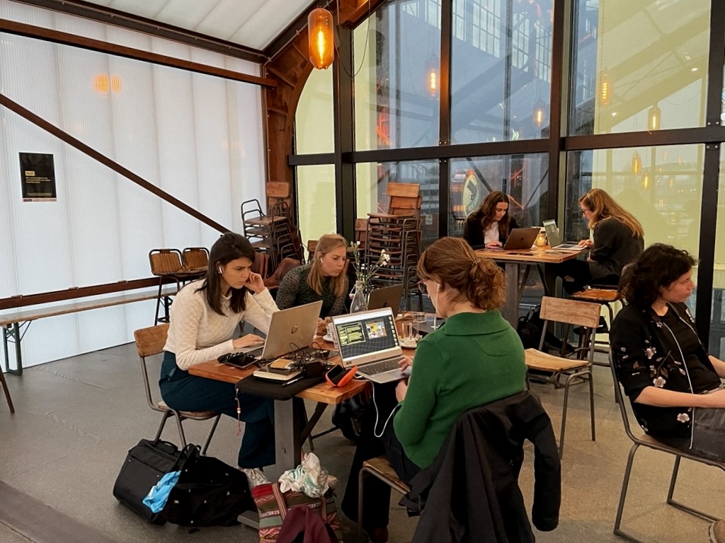 Multiple people playing KLIF behind their laptops.