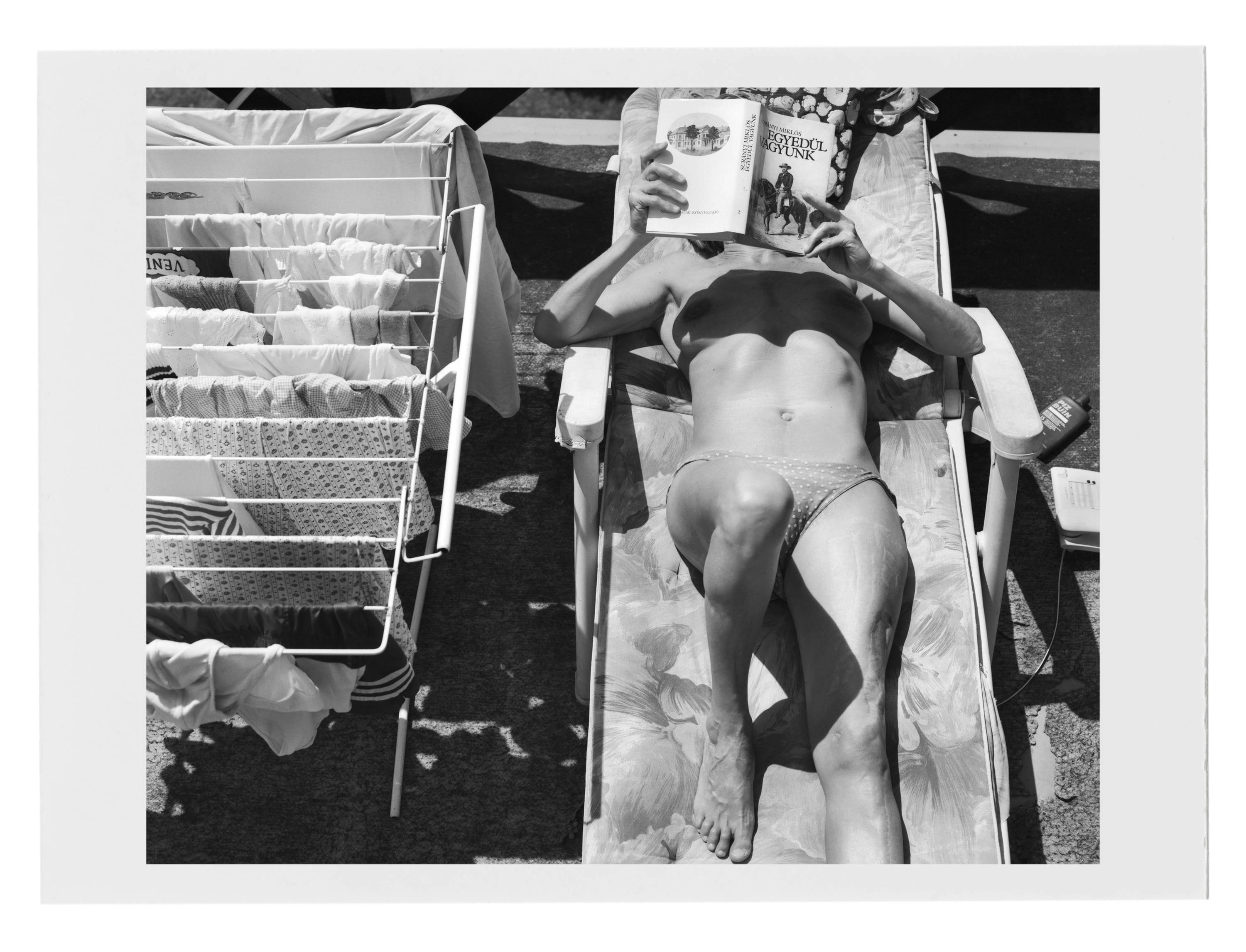 a woman sunbathing and reading
