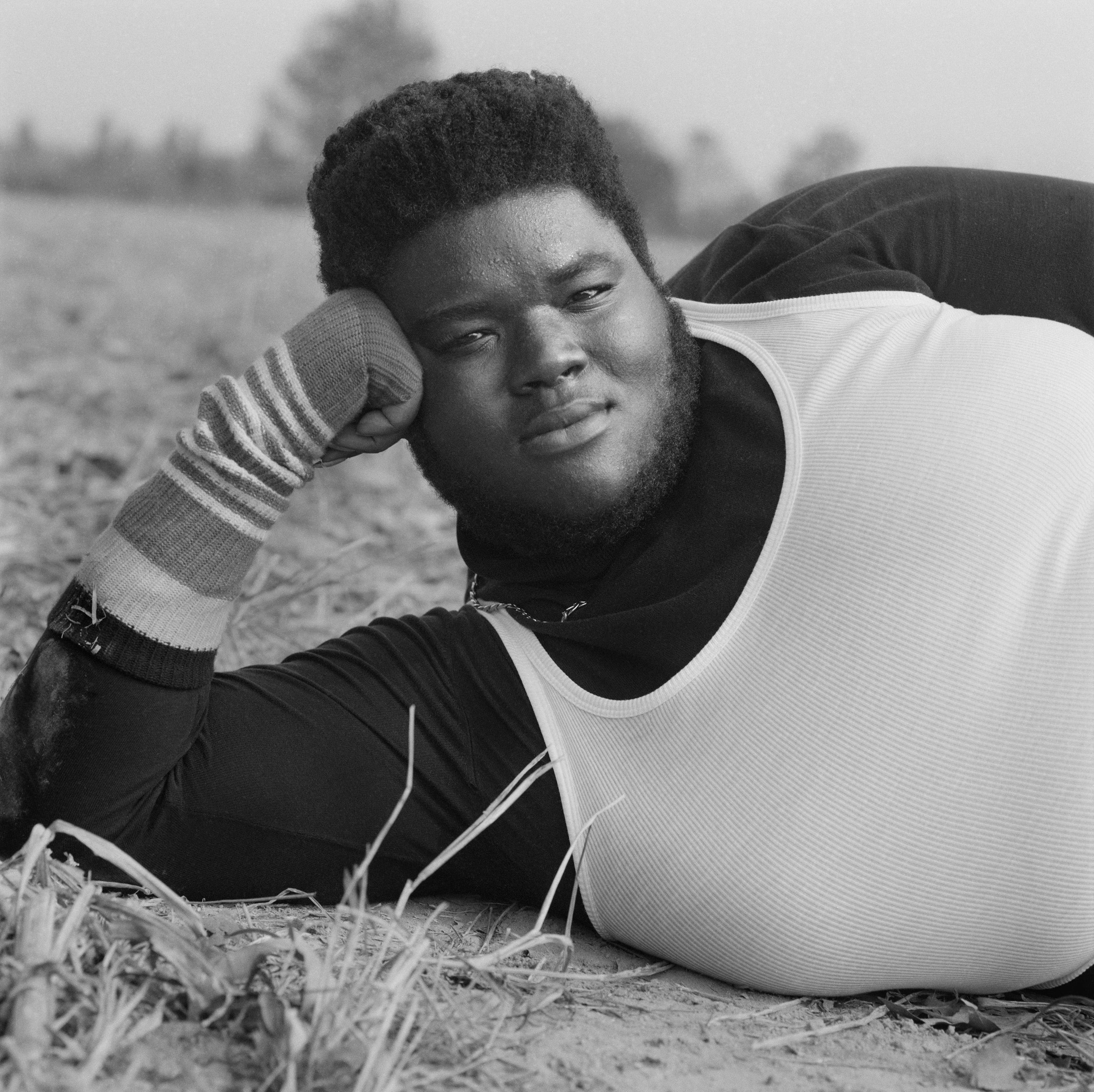 black man laying on a field 