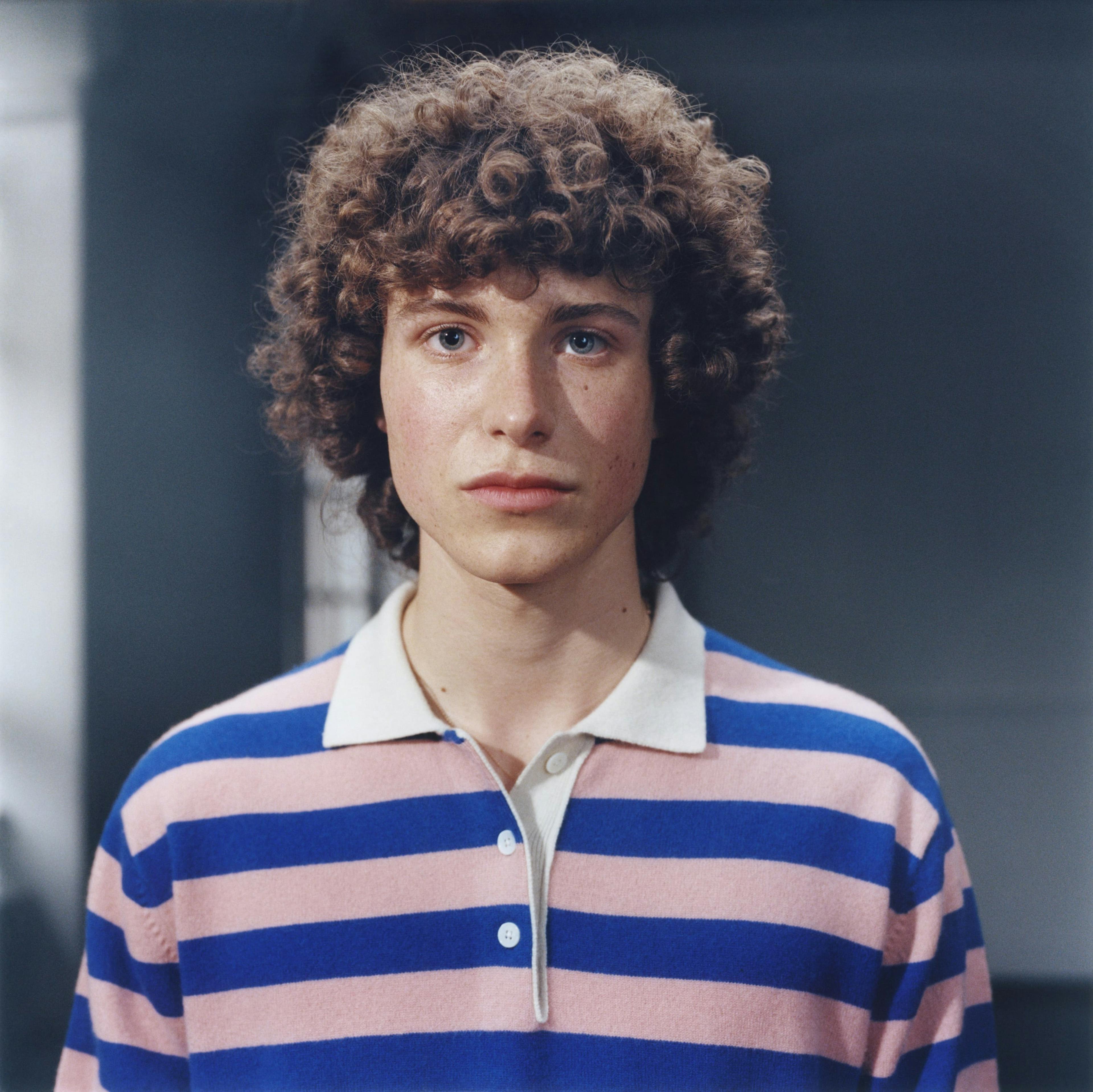 curly man in a striped shirt