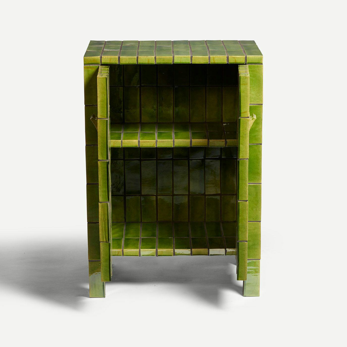 A green tiled cupboard with its doors open and two shelves inside