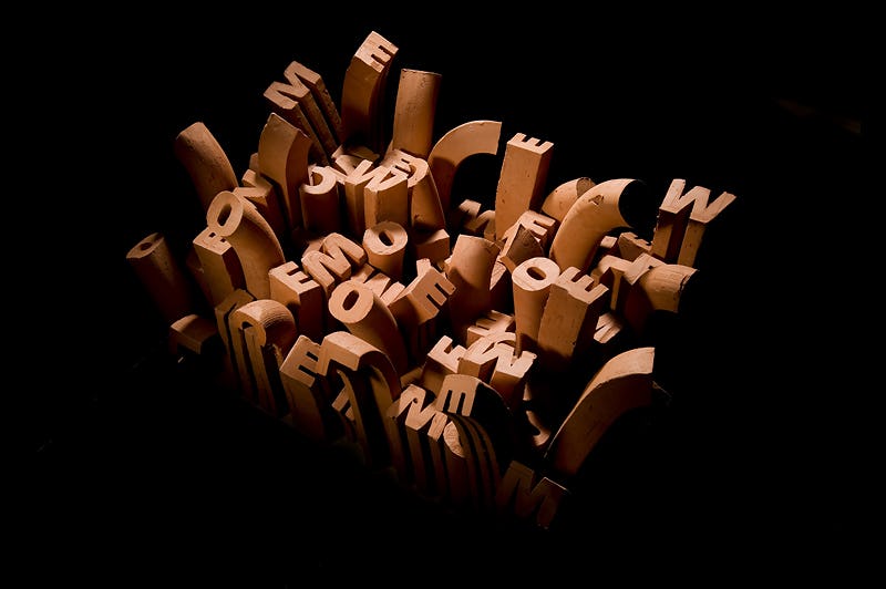 A ceramic sculpture with extruded letters jumbled together