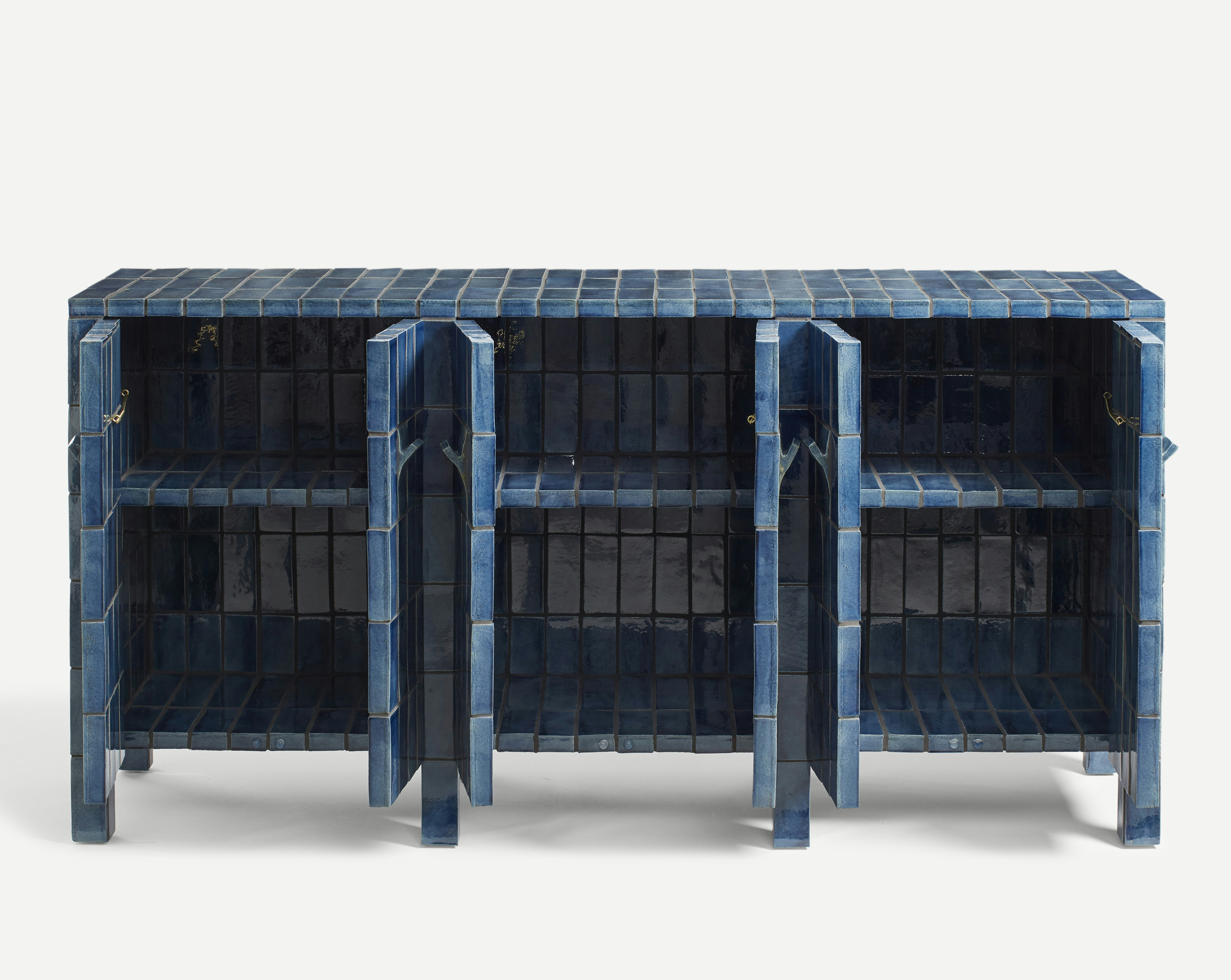 A sideboard clad in handmade blue tiles with its six doors standing open