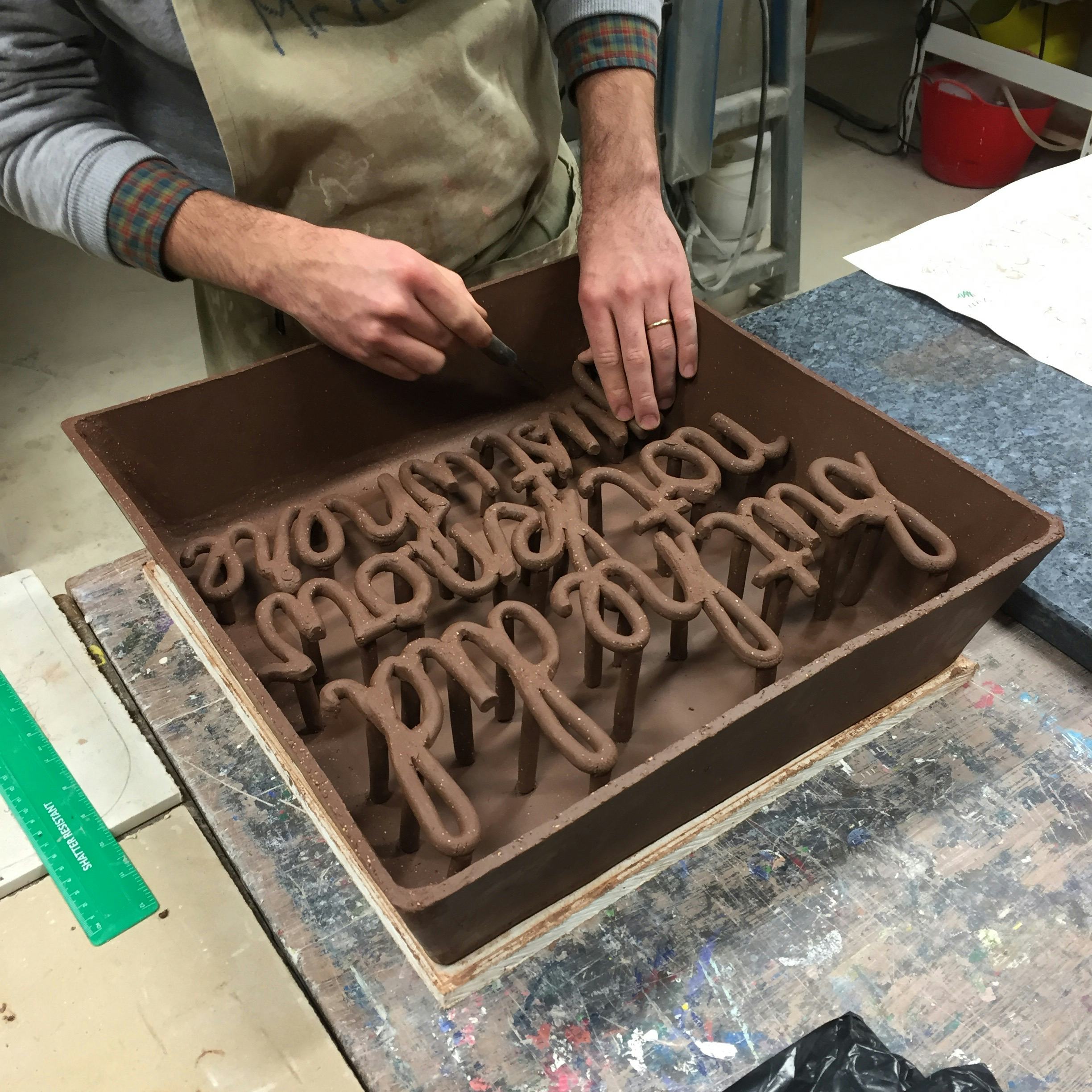 An artist’s hands making a ceramic artwork