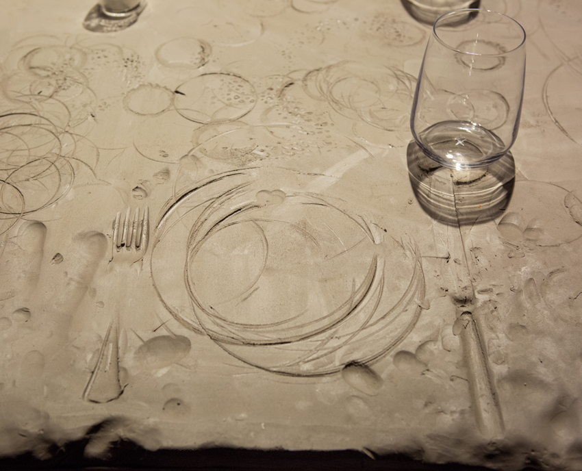 A large piece of clay shows impressions where plates and cutlery were placed