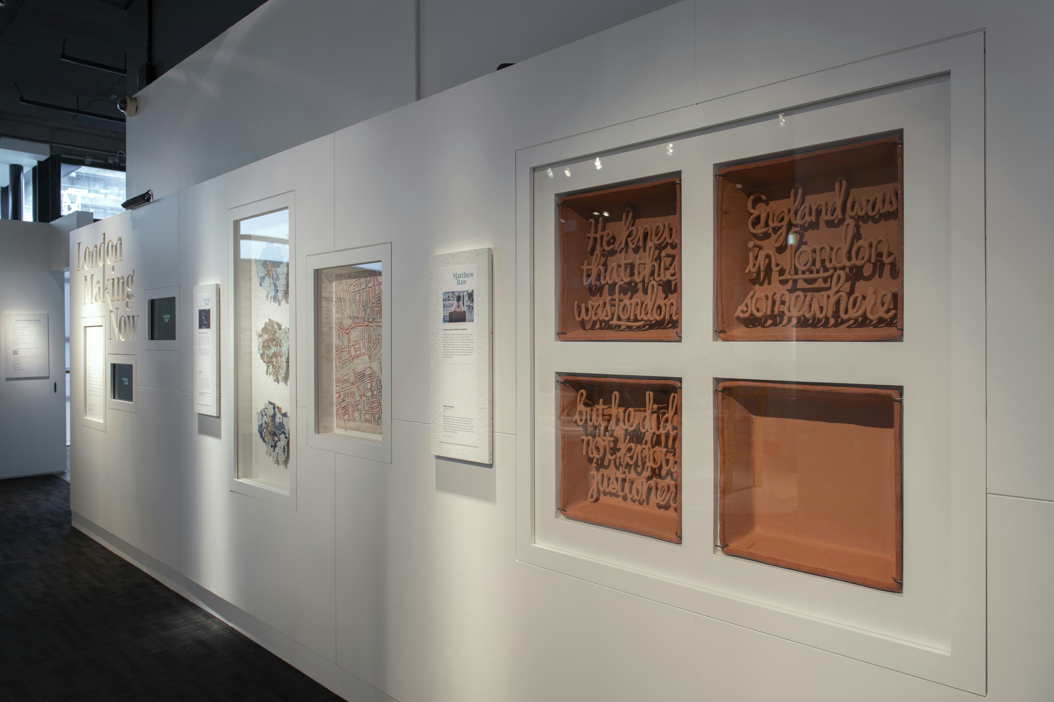 A ceramic artwork in four pieces is displayed in a gallery space alongside other pieces