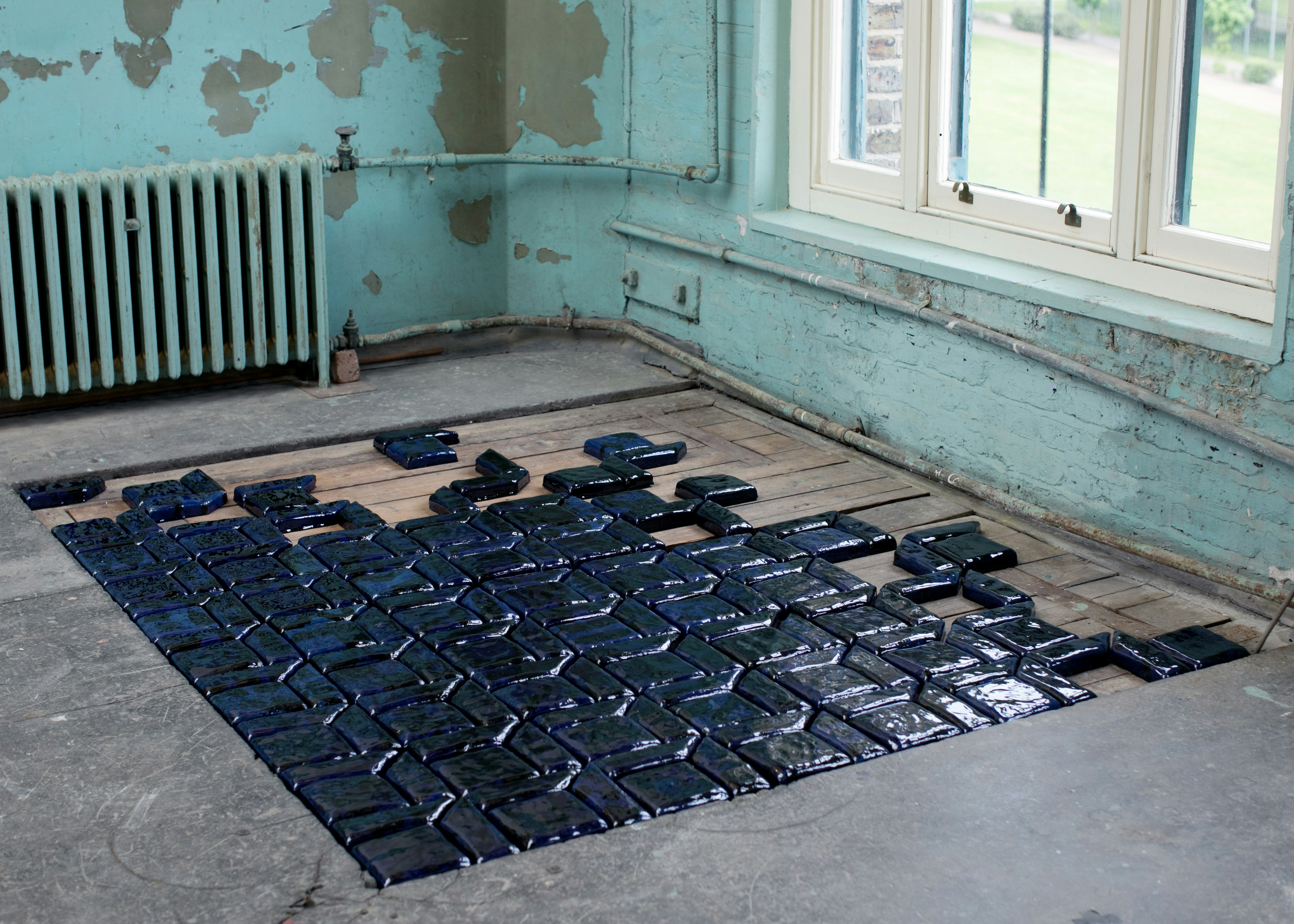Blue tiles placed into the floor of an exhibition