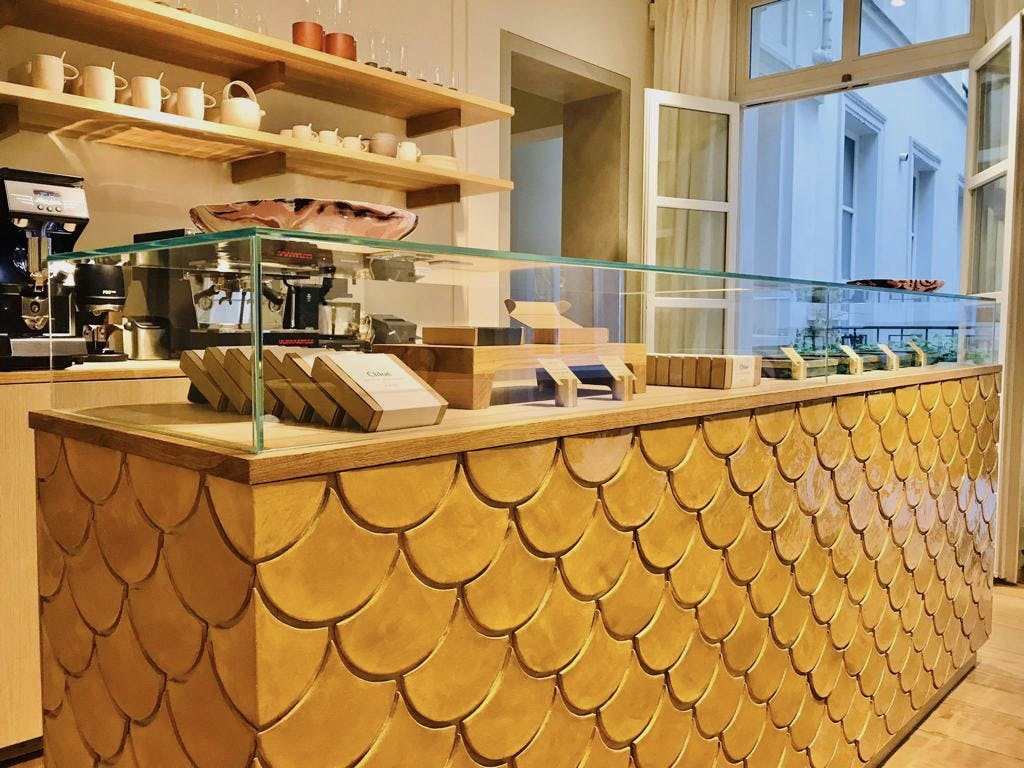 A cafe counter with the base covered in yellow hand-made tiles
