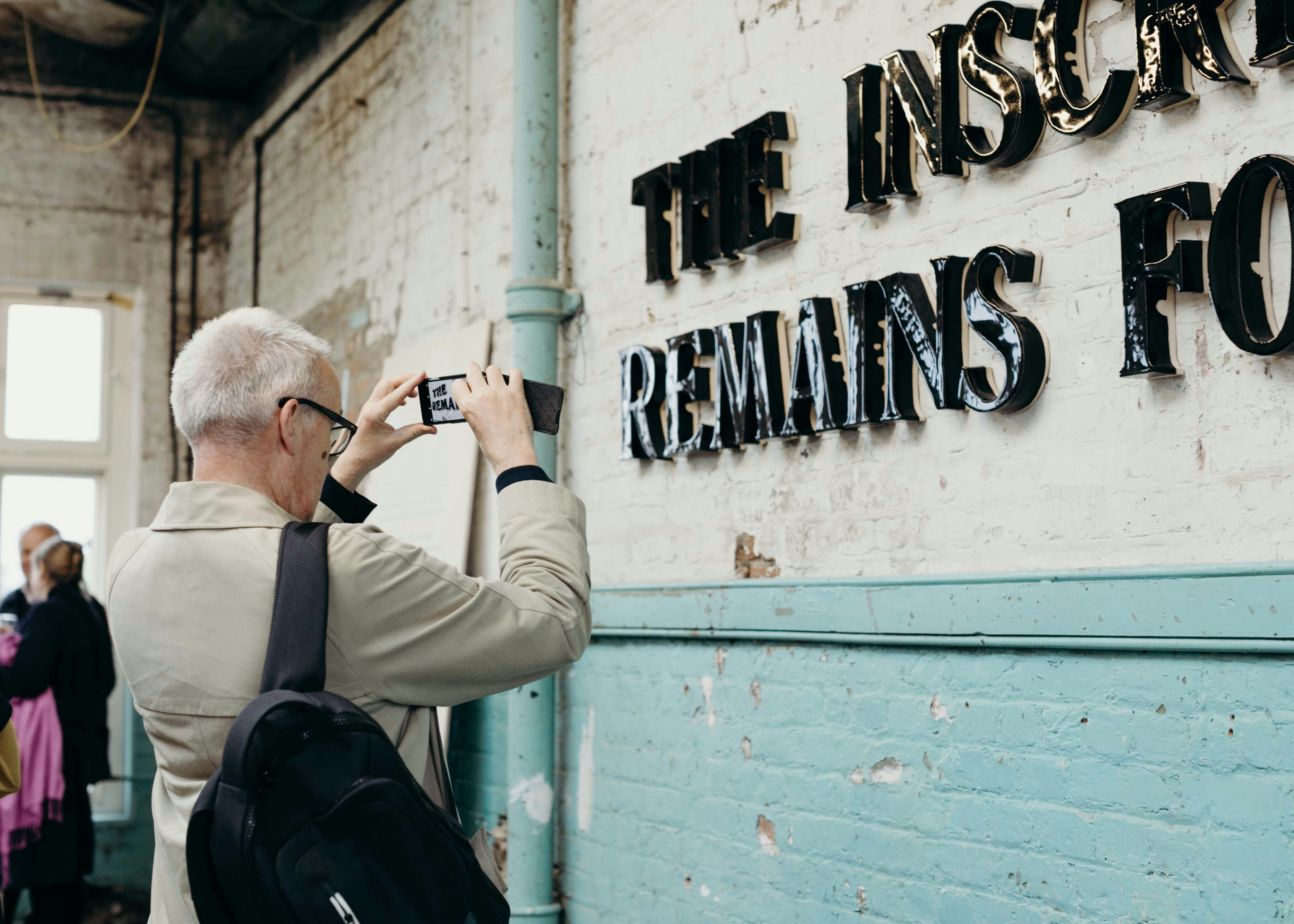 A visitor photographs an artwork at Matthew Raw’s 2019 exhibition ‘CLAD’