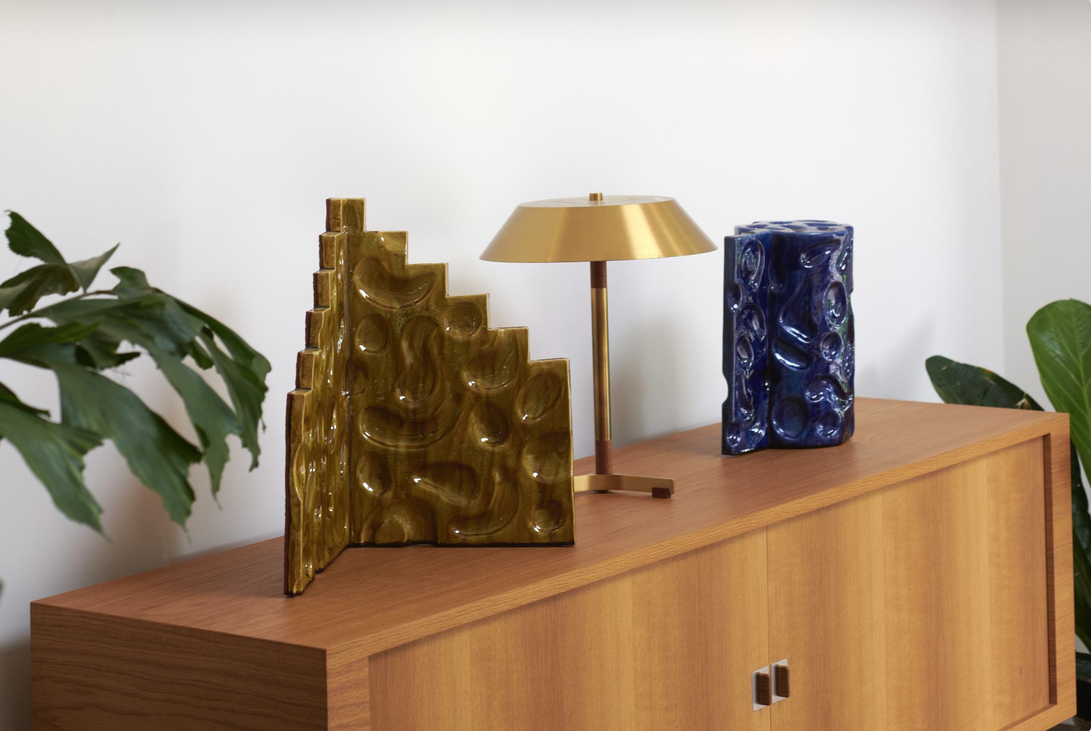 Two artworks sit on top of a cabinet
