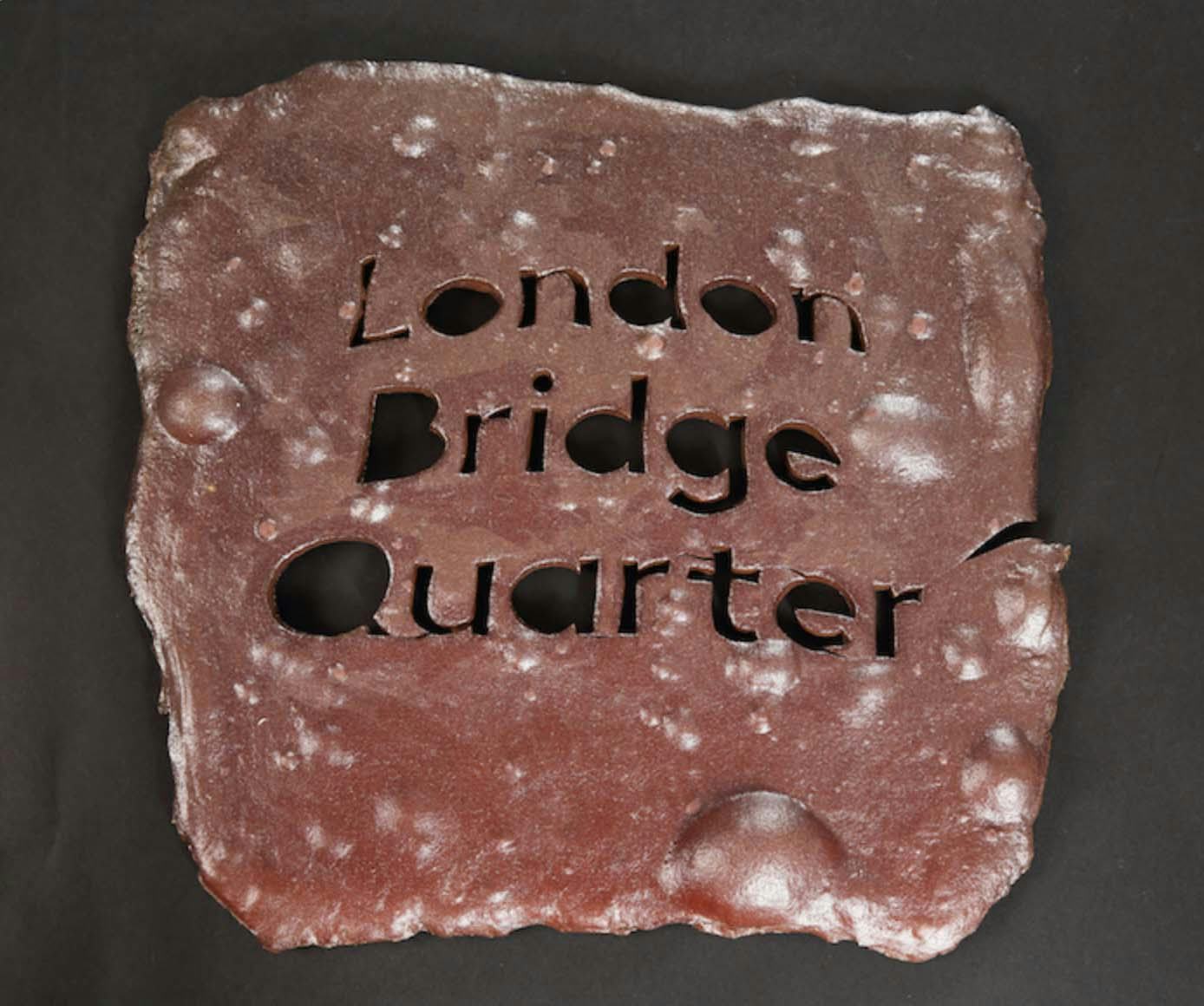 A rough ceramic tile with the words ‘London Bridge Quarter’ cut out