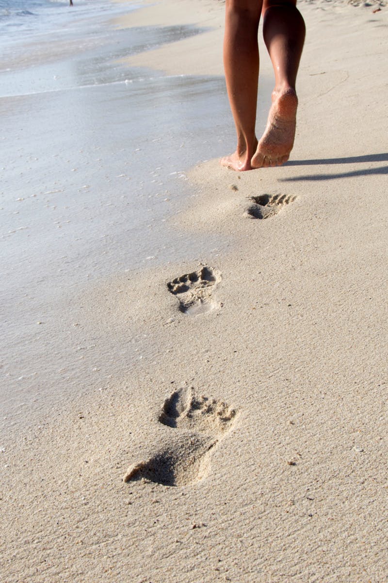 Fille qui marche dans le sable sereinement