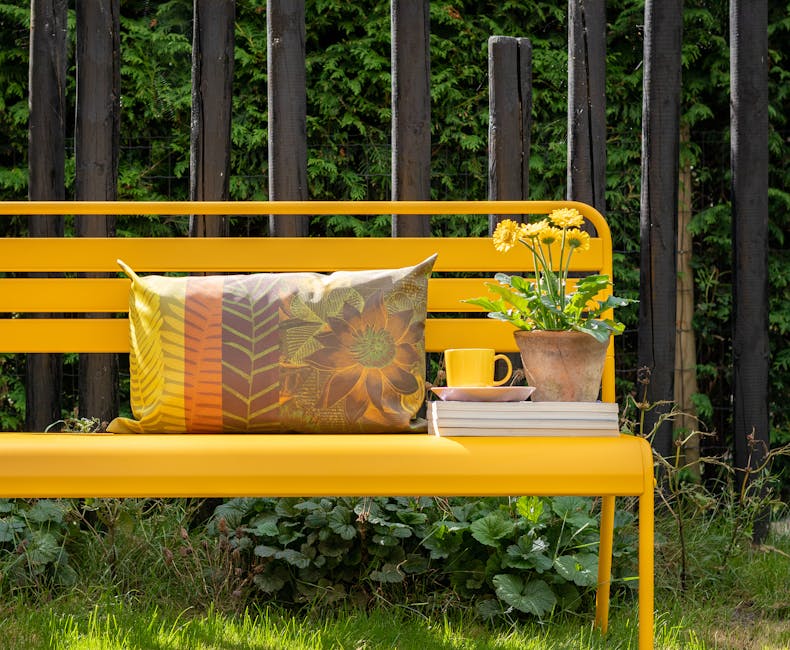 Okergele metalen tuinbank Max in de tuin