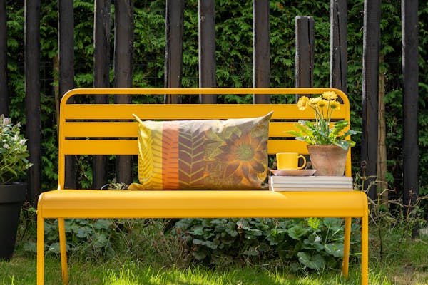 Ochre yellow metal garden bench Max in the garden
