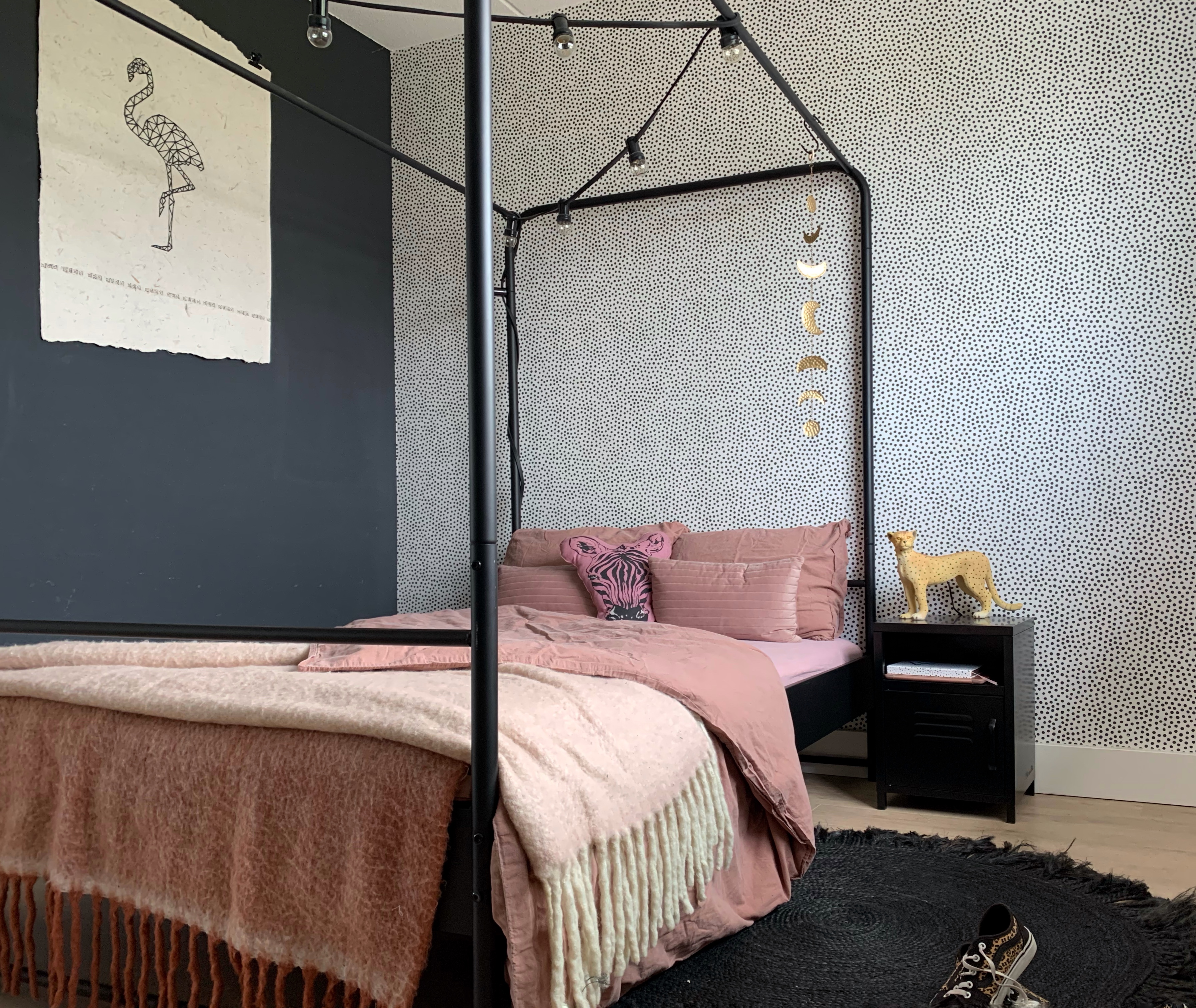 Schwarzes Nachttischchen neben dem Bett im Schlafzimmer