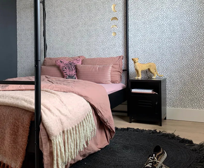 Black bedside table next to the bed in the bedroom