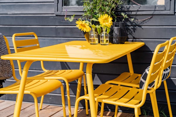 MaximaVida stoelen geel Max dichtbij water met zonnebloemen