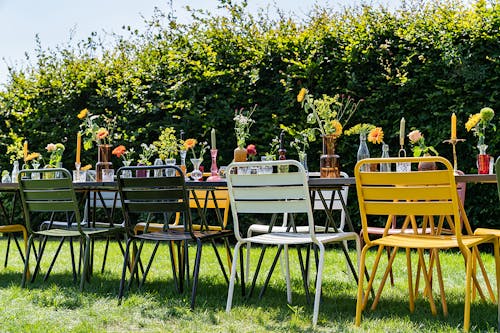 All the colours of our Max chairs on a long table in the grass 