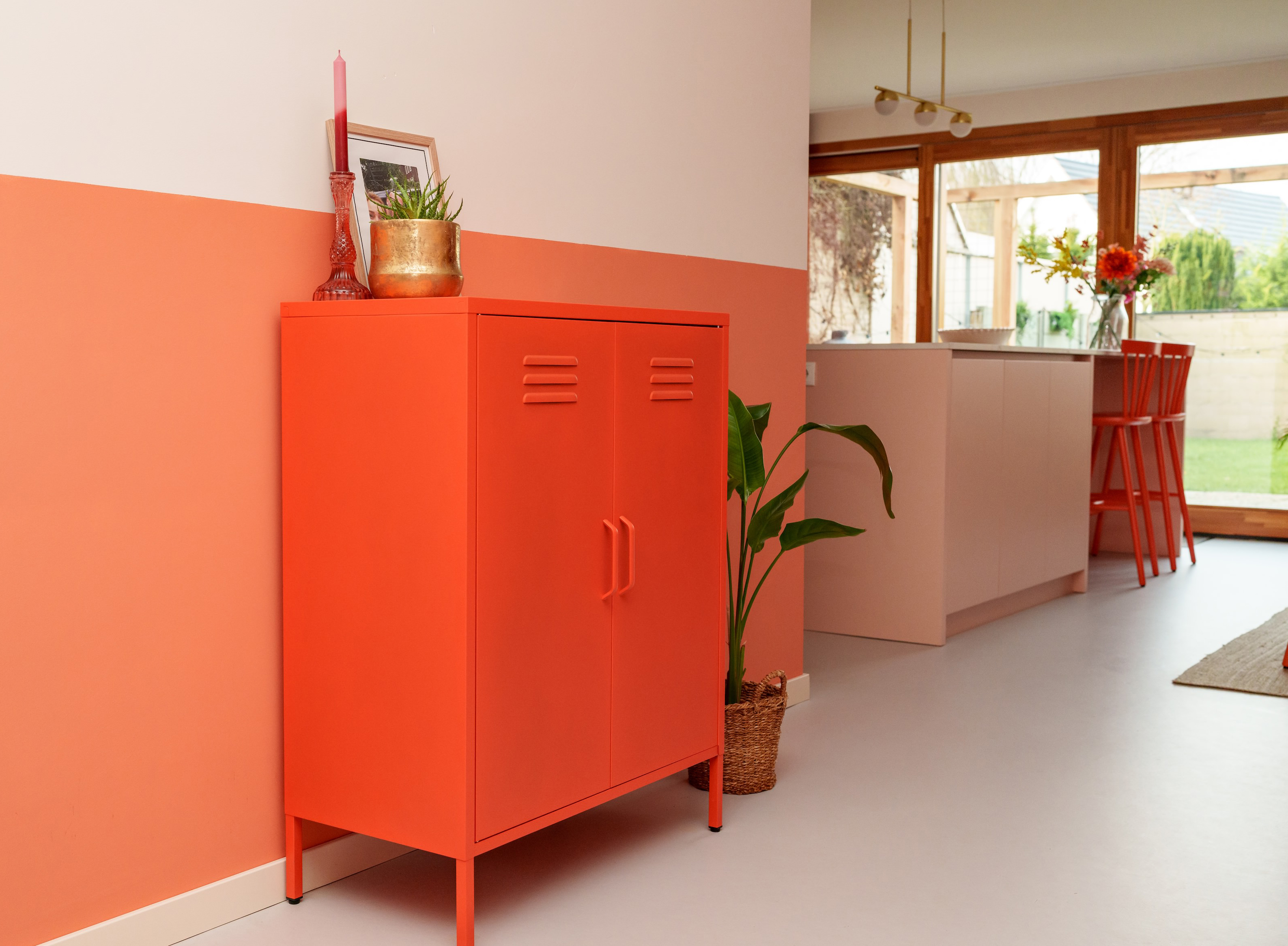 Metalen lockerkast Finn in oranje in de woonkamer
