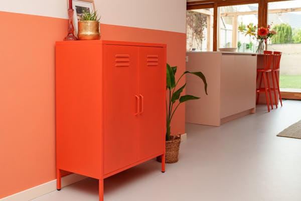Metalen lockerkast Finn in oranje in de woonkamer