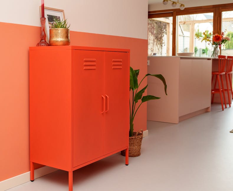 Metalen lockerkast Finn in oranje in de woonkamer