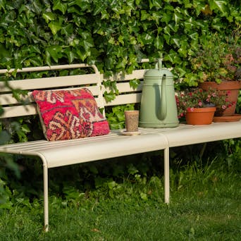 Metall-Gartenbank Max Elfenbein mit Kissen und Pflanzen