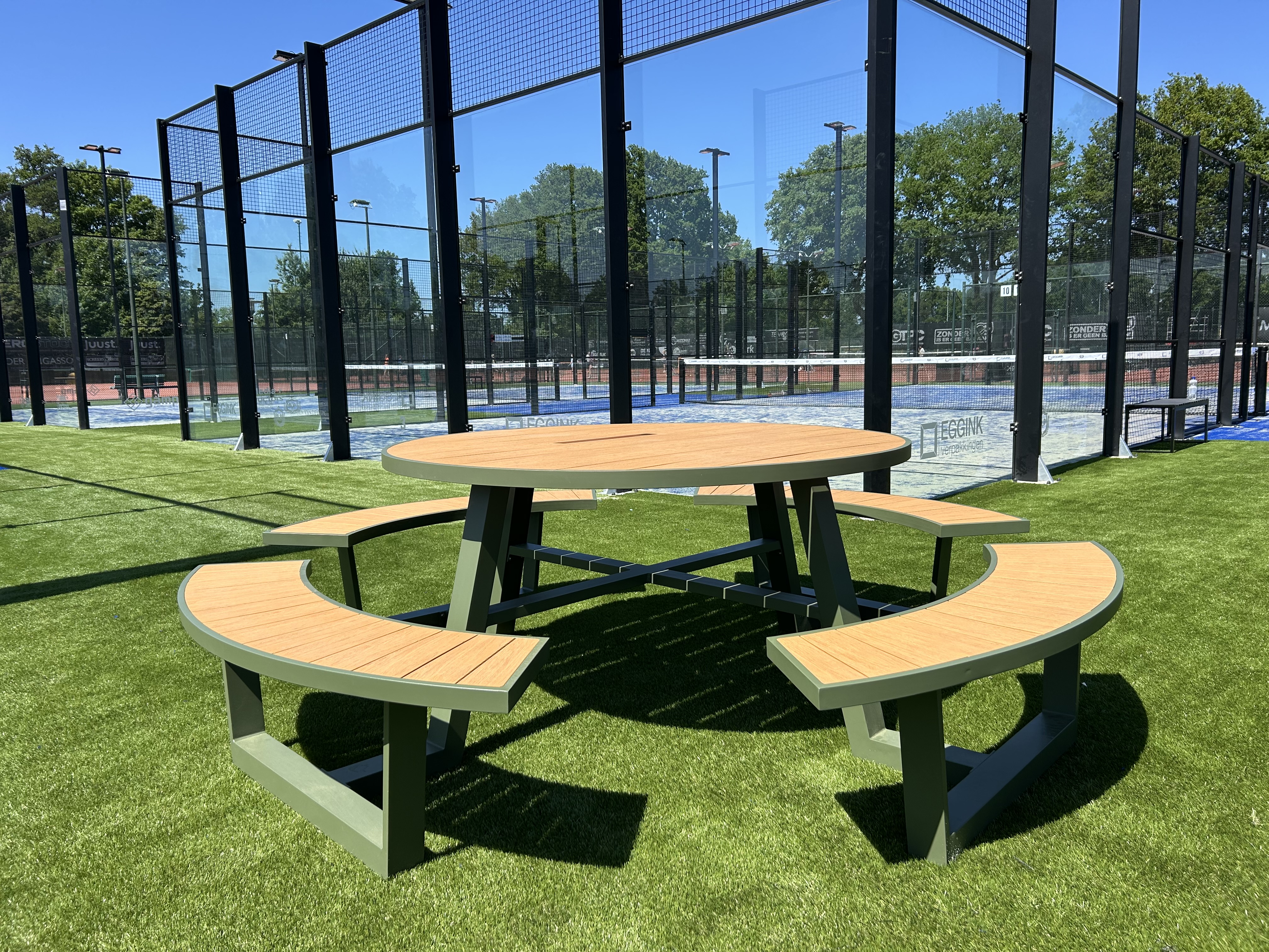 runder picknicktisch aus aluminium in olivgrün an einem padelplatz