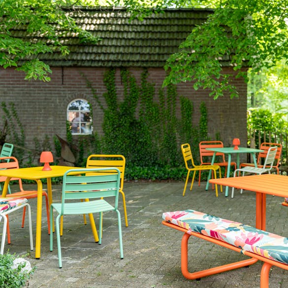Vaiana picknicktafel kussens op Max picknicktafel oranje op terras met Max tuinmeubelen