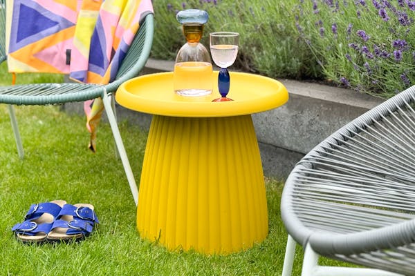 Ochre yellow plastic outdoor side table Mila in the garden