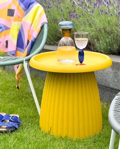 Okergele kunststof bijzettafel Mila buiten in de tuin