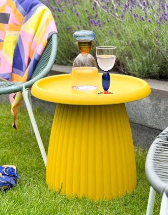 Ochre yellow plastic side table Mila outside in the garden