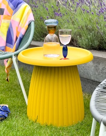 Okergele kunststof bijzettafel Mila buiten in de tuin