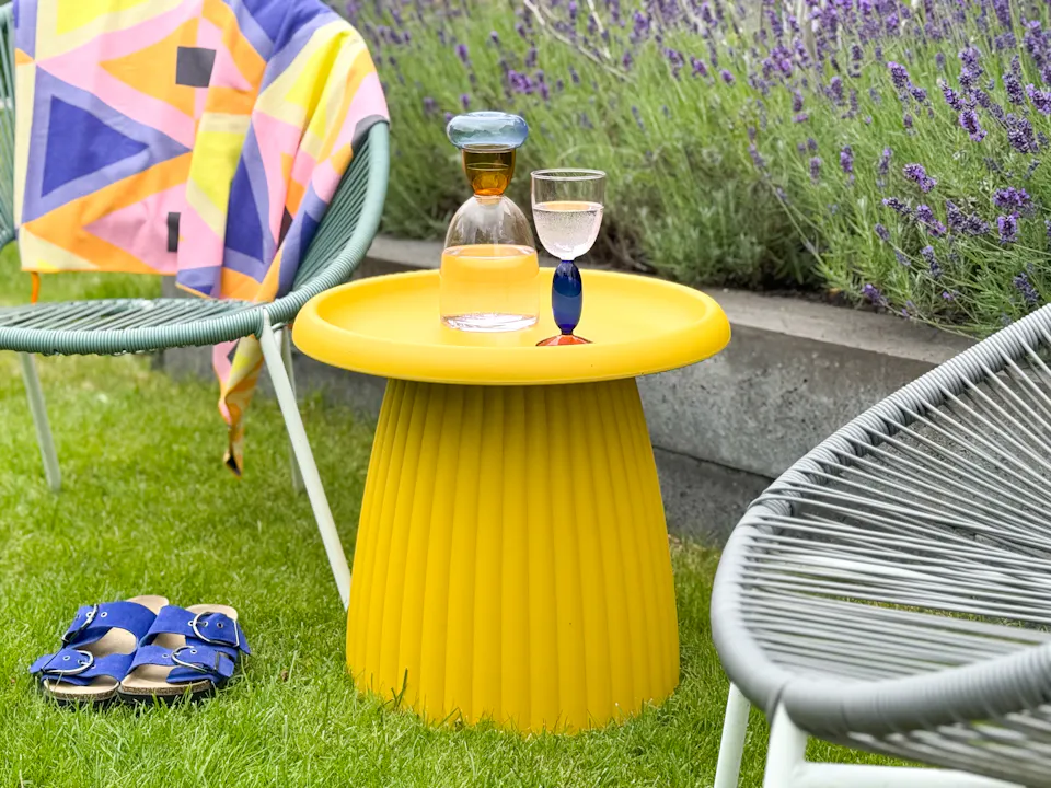 Okergele kunststof bijzettafel Mila buiten in de tuin