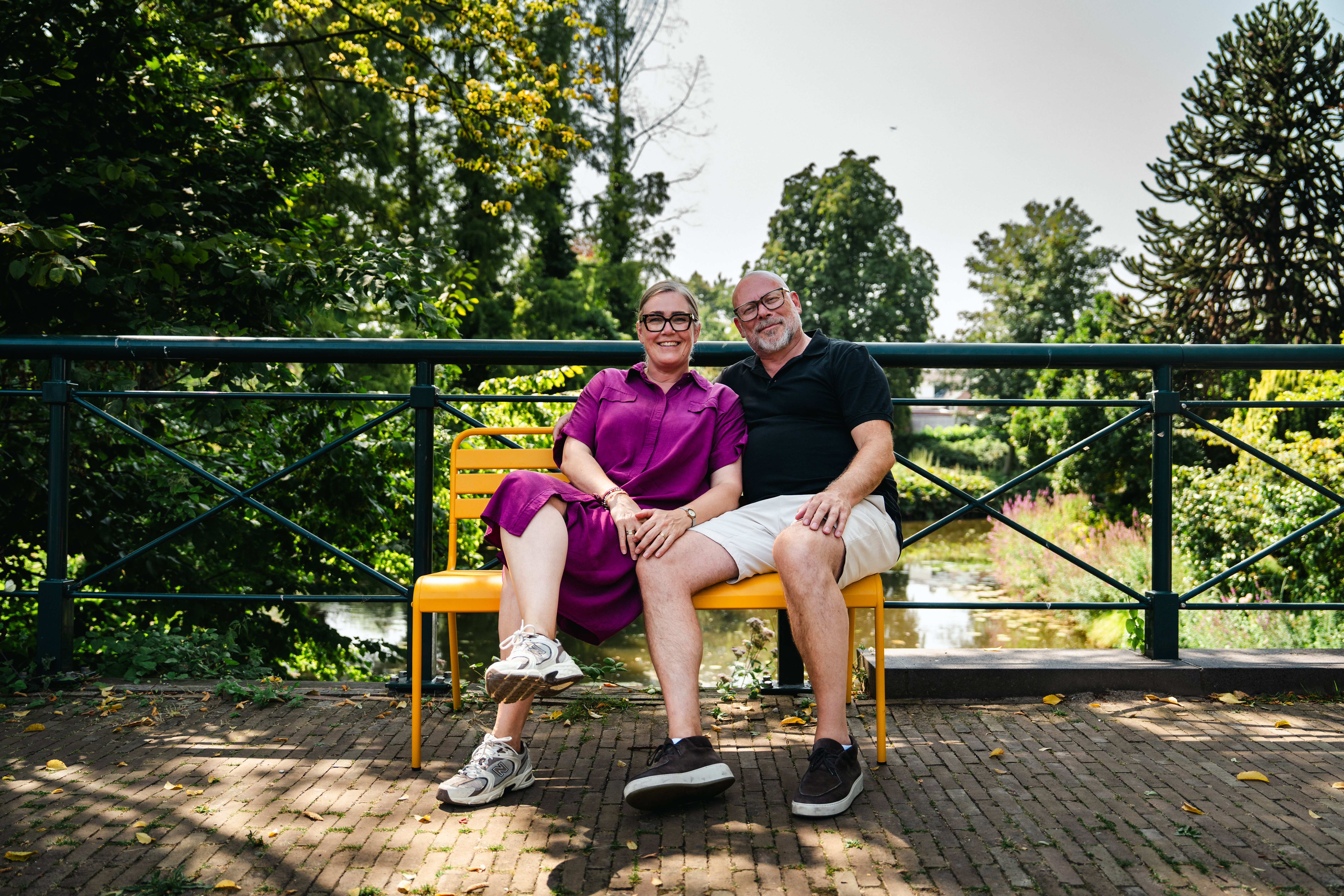 Suzanne en  Jeroen op het okergele Max tuinbankje op de brug in Groenlo