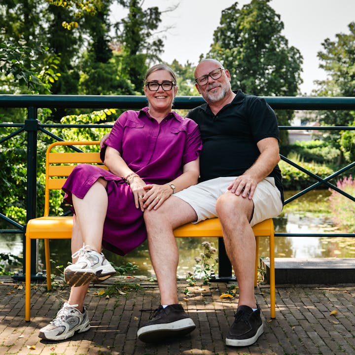 Suzanne en Jeroen op het okergele Max tuinbankje op de brug in Groenlo