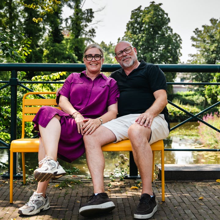Suzanne en Jeroen op het okergele Max tuinbankje op de brug in Groenlo