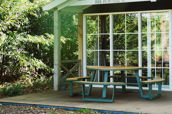 Ronde aluminium picknicktafel Bermuda in olijfgroen op veranda Bremstruik