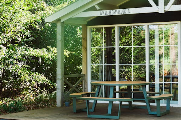 Round aluminium Bermuda picnic table in olive green on veranda Bramble bush