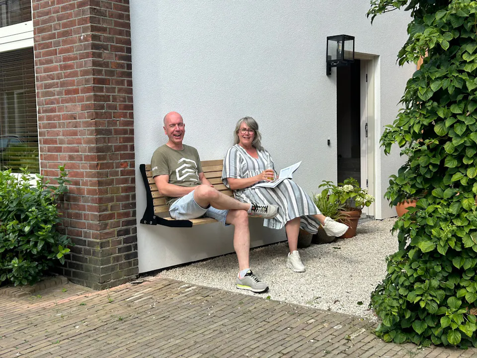 Stel op gevelbank Jordaan aan zijkant huis