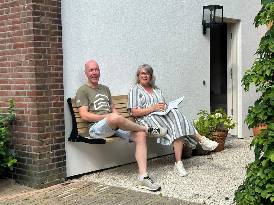 Stel op gevelbank Jordaan aan zijkant huis