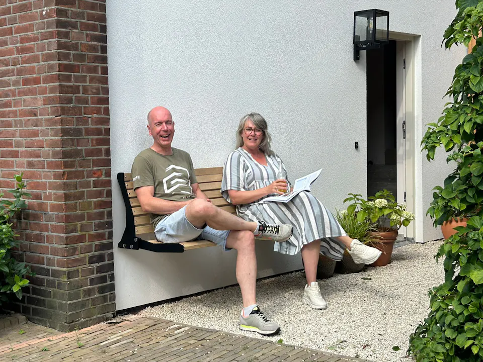 Stel op gevelbank Jordaan aan zijkant huis