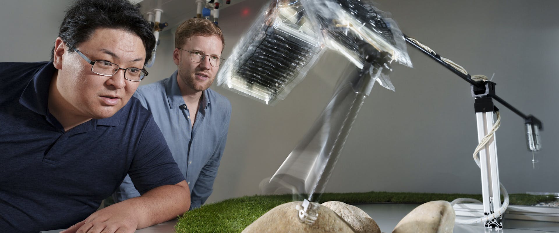 Toshihiko Fukushima und Thomas Buchner beobachten, wie das Roboterbein im Kreis springt. | ©MPI für Intelligente Systeme/Wolfram Scheible Toshihiko Fukushima und Thomas Buchner beobachten, wie das Roboterbein im Kreis springt.