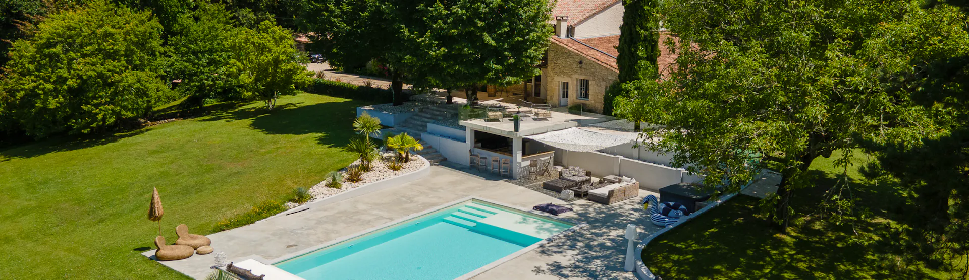 Vue aérienne d'une piscine et d'un jardin.