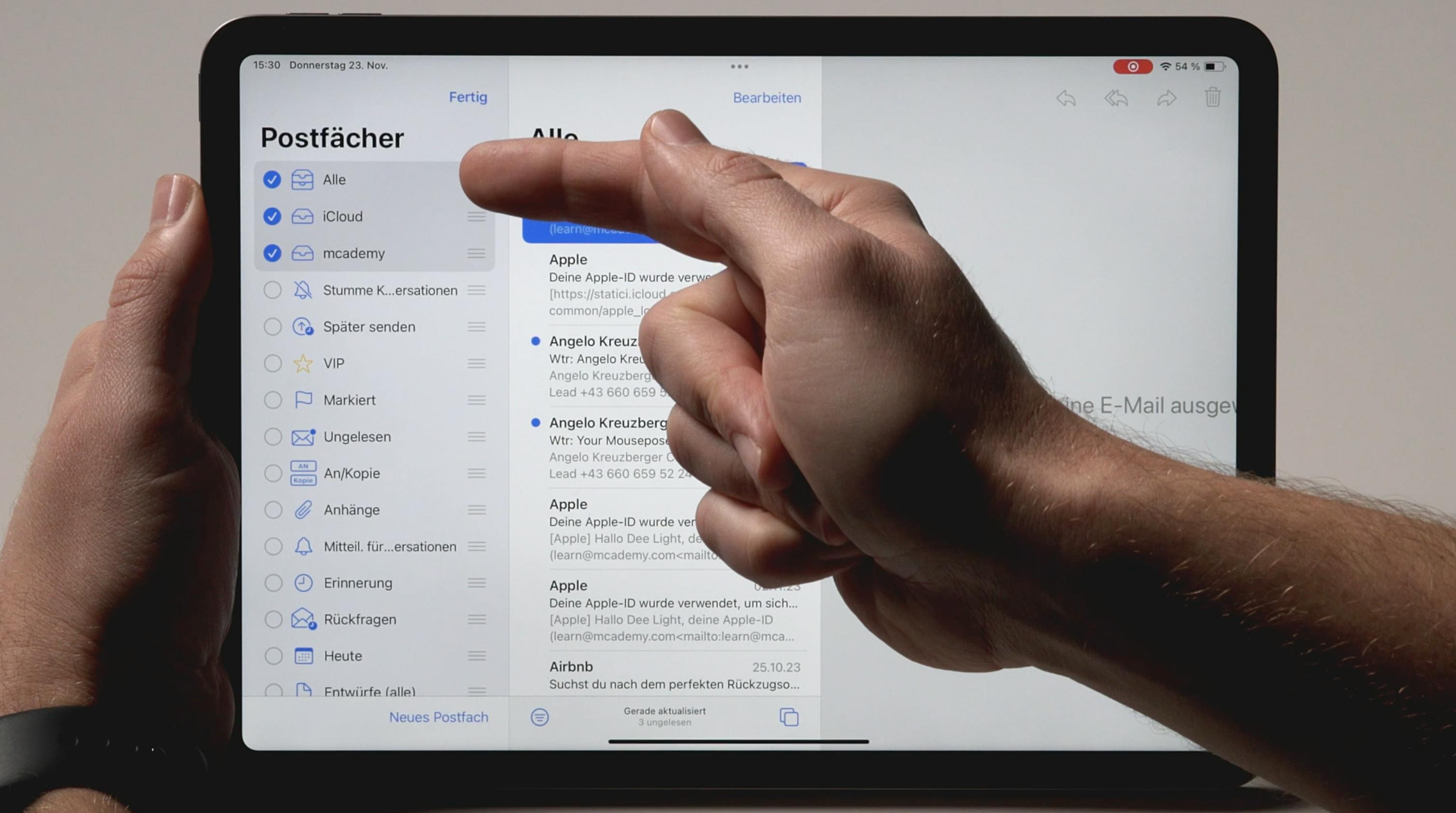Person zeigt auf iPad mit geöffneter Mail App