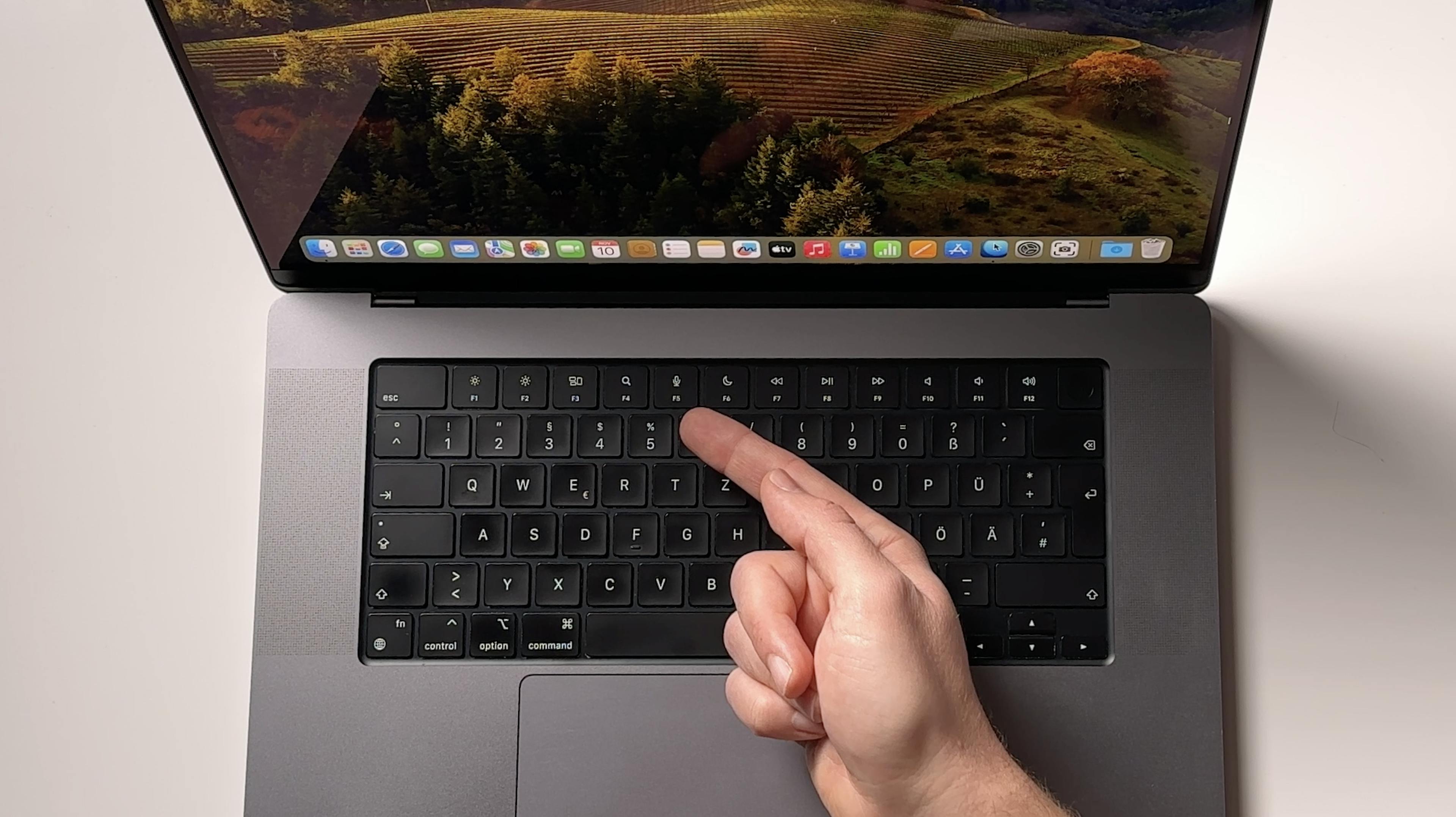 Person pointing at MacBook