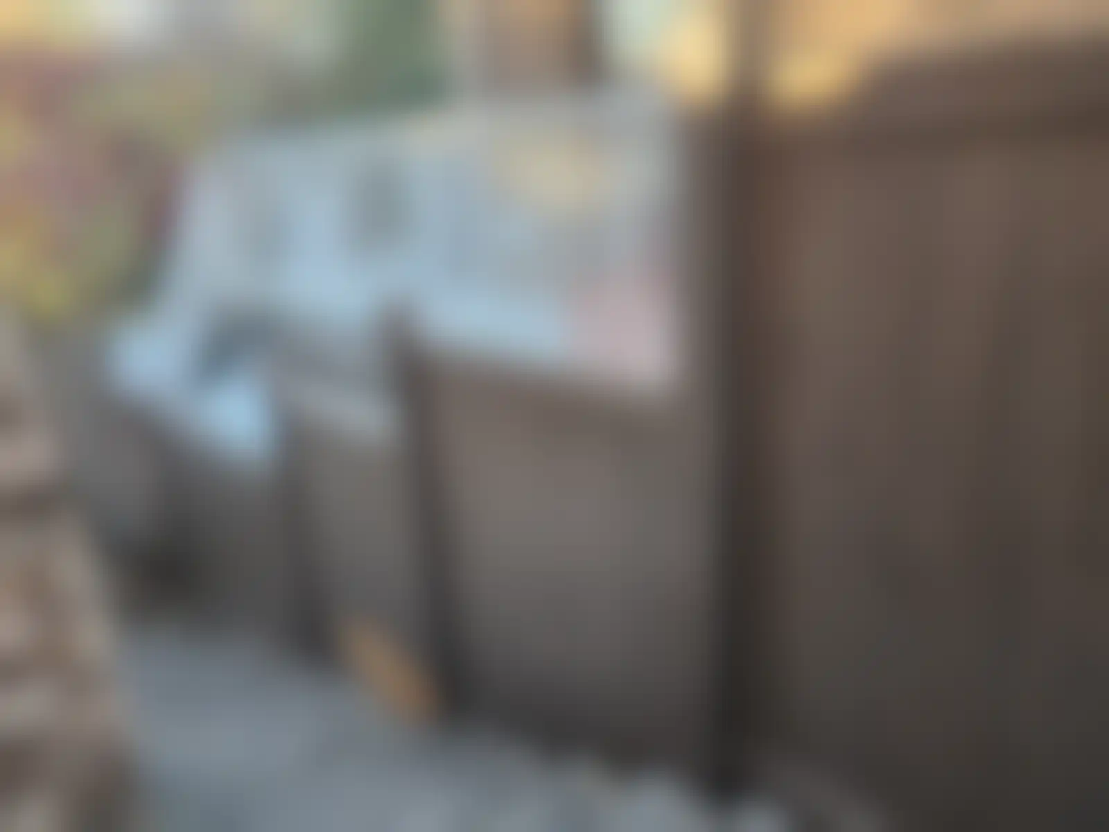A brown vinyl fence next to a set of outdoor stairs in a residential backyard.