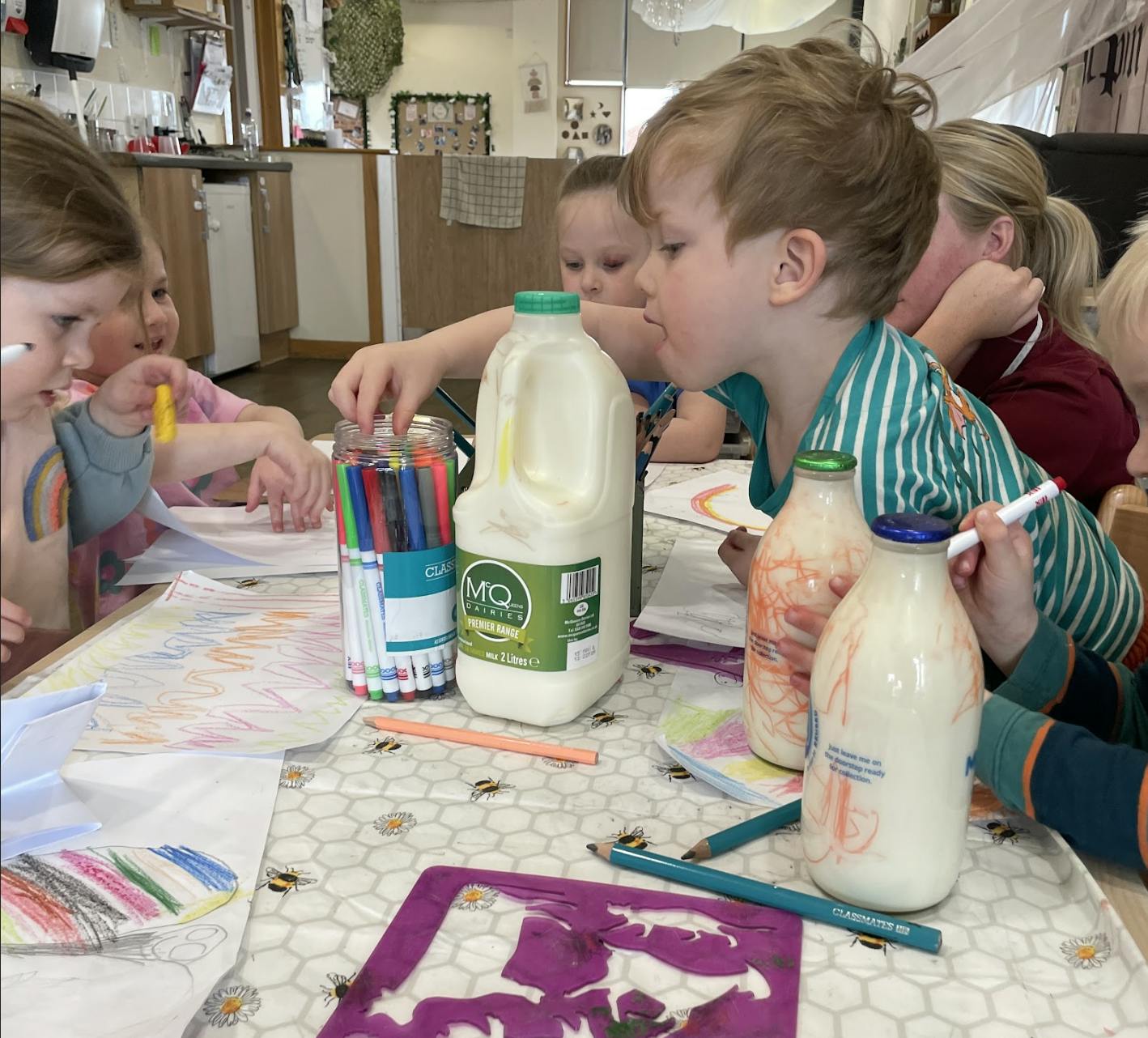 Children playing around milk bottle