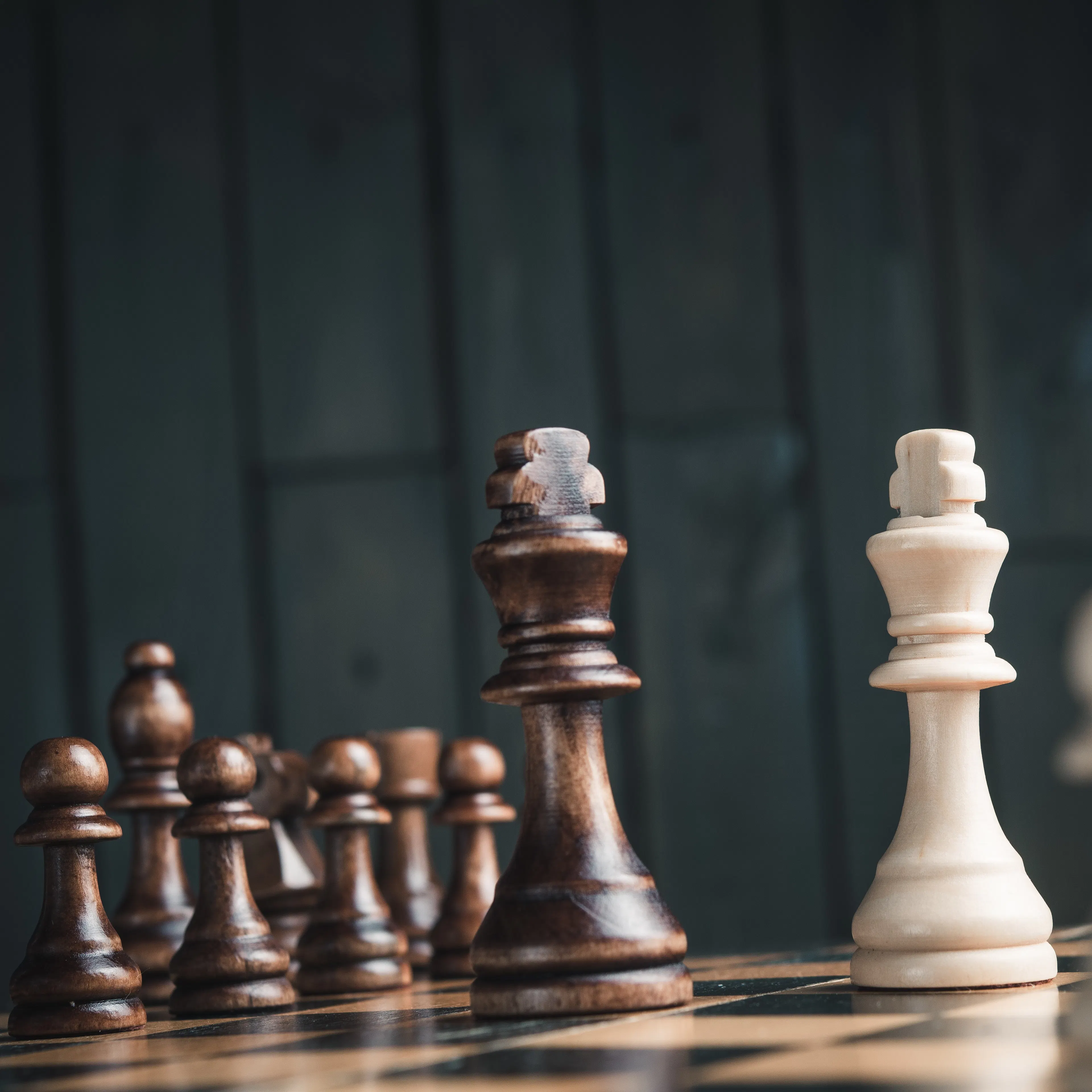 brown and white chess board with kings facing